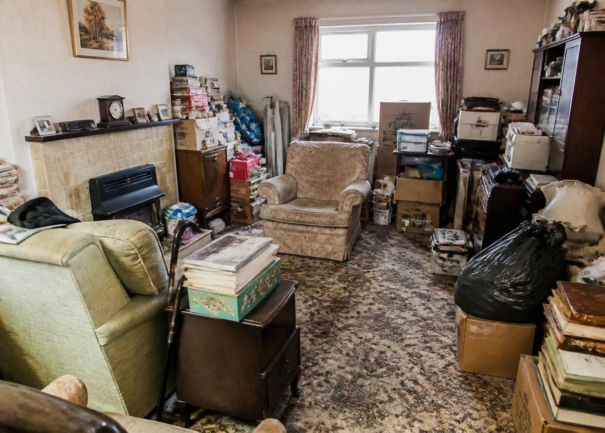 Cluttered room with years of belongings โ the type of property we regularly clear